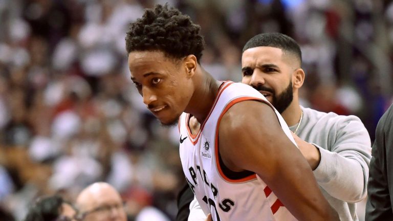 Toronto Raptors guard DeMar DeRozan (10) is embraced by Toronto-born rapper Drake as he's pulled to the bench in the final minutes of second half NBA basketball action against the Washington Wizards, in Toronto on Tuesday, April 17, 2018. (Nathan Denette/CP Photo)