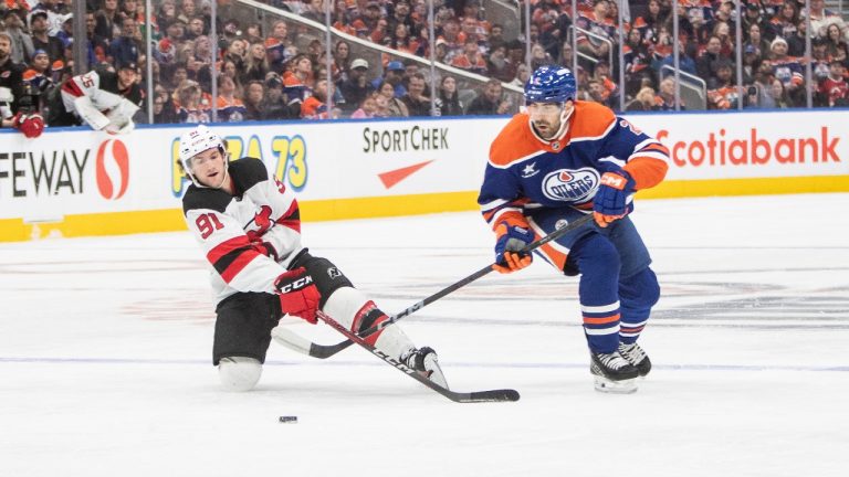 New Jersey Devils' Dawson Mercer (91) battles Edmonton Oilers' Evan Bouchard (2) for the puck during second period NHL action in Edmonton, Monday, Nov. 4, 2024. (CP)