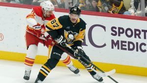 Pittsburgh Penguins' Sidney Crosby (87) looks to pass the puck as he's defended by Calgary Flames' Jonathan Huberdeau (10) during the first period of an NHL hockey game Saturday, Nov. 30, 2024, in Pittsburgh. (Matt Freed/AP)