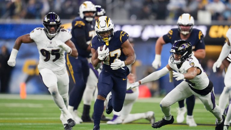 Los Angeles Chargers running back J.K. Dobbins (27) runs past Baltimore Ravens safety Kyle Hamilton (14) during the first half of an NFL game Monday, Nov. 25, 2024, in Inglewood, Calif. (AP/Eric Thayer)