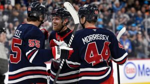 Winnipeg Jets' Nikolaj Ehlers (27) celebrates his goal against the Dallas Stars with Mark Scheifele (55) and Josh Morrissey (44) during second period NHL hockey action in Winnipeg on Saturday November 9, 2024. (Fred Greenslade/CP)