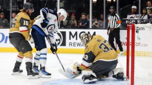 Winnipeg Jets centre Cole Perfetti (91) scores against Vegas Golden Knights defenceman Noah Hanifin (15) and goaltender Adin Hill (33) during the first period of an NHL hockey game Friday, Nov. 29, 2024, in Las Vegas. (Ian Maule/AP)