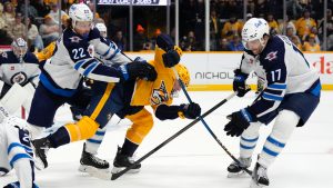 Nashville Predators' Fedor Svechkov, centre, tries to control the puck between Winnipeg Jets' Mason Appleton (22) and Adam Lowry (17) during the second period of an NHL hockey game Saturday, Nov. 23, 2024, in Nashville, Tenn. (Mark Humphrey/AP)