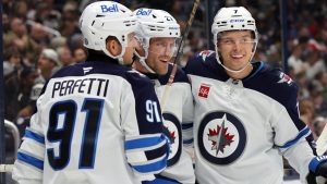 Winnipeg Jets forward Nikolaj Ehlers, centre, celebrates his second goal against the Columbus Blue Jackets with teammate forward Cole Perfetti, left, and forward Vladislav Namestnikov. (AP Photo/Paul Vernon)