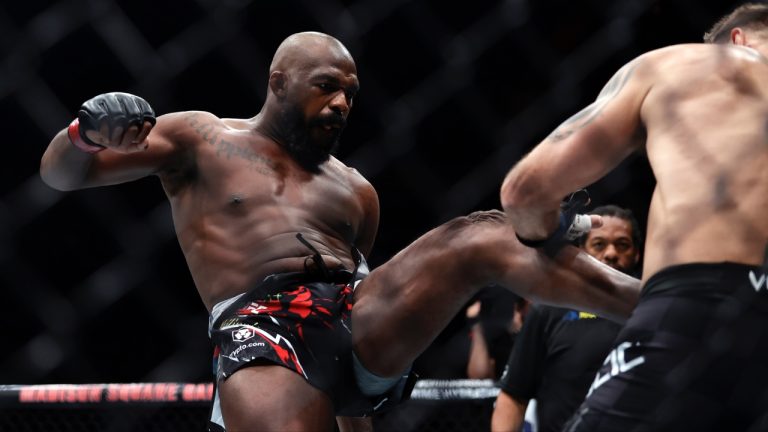 Jon Jones kicks Stipe Miocic in a UFC 309 mixed martial arts heavyweight title bout in New York. (Adam Hunger/AP)