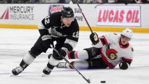 Los Angeles Kings left wing Trevor Moore, left, takes the puck as Ottawa Senators center Tim Stützle falls during the second period of an NHL hockey game. (Mark J. Terrill/AP)