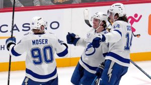 Tampa Bay Lightning's Brayden Point, center, celebrates with J.J. Moser (90) and Conor Geekie (14) after getting the game-winning overtime goal during an NHL hockey game against the Pittsburgh Penguins, Tuesday, Nov. 19, 2024, in Pittsburgh. The Lightning won 3-2. (AP Photo/Gene J. Puskar)