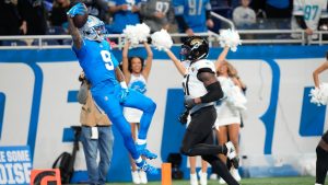 Detroit Lions wide receiver Jameson Williams (9) celebrates his 64-yard touchdown reception as Jacksonville Jaguars linebacker Ventrell Miller (51) looks on during the second half of an NFL football game, Sunday, Nov. 17, 2024, in Detroit.(AP Photo/Carlos Osorio)