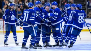 Toronto Maple Leafs right wing Mitch Marner (16), centre, celebrates with teammates after scoring in overtime to defeat the Edmonton Oilers 4-3, during an NHL hockey game, in Toronto, Saturday, Nov. 16, 2024. (Christopher Katsarov/CP)