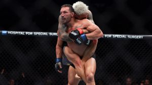 Michael Chandler with Charles Oliveira on his back in a UFC 309 mixed martial arts lightweight bout. (Adam Hunger/AP)