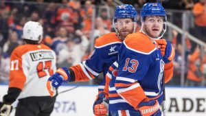 Philadelphia Flyers' Jett Luchanko (17) skates off as Edmonton Oilers' Mattias Janmark (13) and Connor Brown (28) celebrate their goal during second period NHL action in Edmonton on Tuesday October 15, 2024. THE CANADIAN PRESS/Amber Bracken