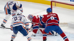 Montreal Canadiens' goaltender Sam Montembeault (35) and Mike Matheson (8) scrabble for the puck as Edmonton Oilers' Zach Hyman (18) and Ryan Nugent-Hopkins (93) look for the rebound shot during first period NHL hockey action in Montreal, Monday, Nov. 18, 2024. (Christinne Muschi/CP)