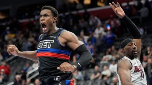 Detroit Pistons center Jalen Duren (0), defended by Miami Heat center Bam Adebayo (13), reacts after a dunk to tie the game in the closing seconds during overtime of an Emirates NBA Cup basketball game, Tuesday, Nov. 12, 2024, in Detroit. (AP Photo/Carlos Osorio)