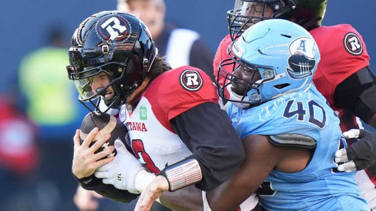 Toronto Argonauts defensive lineman Robbie Smith (40) wraps up Ottawa Redblacks quarterback Dru Brown (3) during first half CFL action in Toronto on Saturday, Oct. 19, 2024. (CP/Frank Gunn)