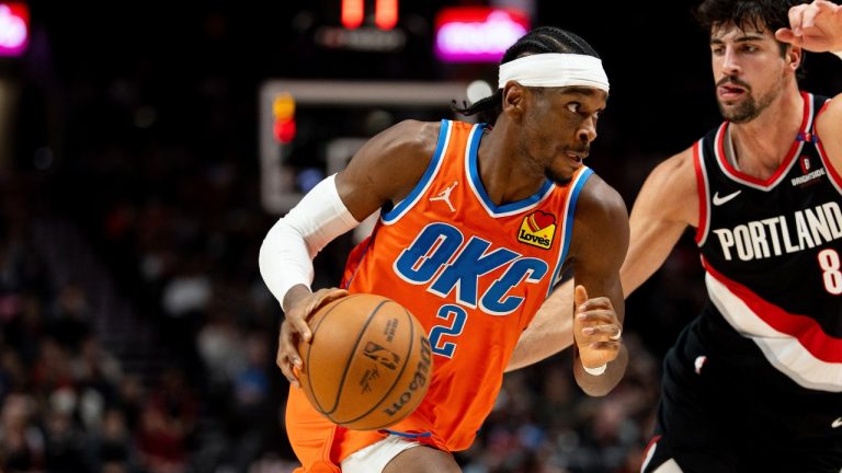 Oklahoma City Thunder guard Shai Gilgeous-Alexander, left, drives to the hoop against Portland Trail Blazers forward Deni Avdija, right, during the first half of an NBA basketball game, Friday, Nov. 1, 2024, in Portland, Ore. (AP Photo/Howard Lao)