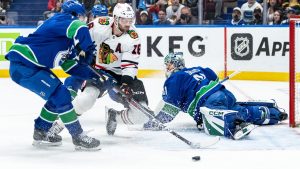 Vancouver Canucks goaltender Arturs Silovs (31) stops Chicago Blackhawks' Jason Dickinson (16) as Vancouver's Quinn Hughes, left, defends during first period NHL hockey action in Vancouver, B.C., Saturday, Nov. 16, 2024. (Ethan Cairns/CP)