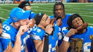 Detroit Lions quarterback Jared Goff (16), from left, wide receiver Amon-Ra St. Brown (14), and running back Jahmyr Gibbs (26) celebrate with turkey after beating the Chicago Bears 23-20 in an NFL football game in Detroit, Thursday, Nov. 28, 2024. (Carlos Osorio/AP)