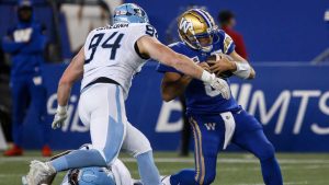 Winnipeg Blue Bombers quarterback Zach Collaros (8) gets tackled by Toronto Argonauts' Jake Ceresna (94) during first half CFL action. (John Woods/CP)