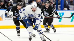 Toronto Maple Leafs centre Auston Matthews (34) gets ahead of Tampa Bay Lightning left wing Brandon Hagel (38) and centre Anthony Cirelli (71) during the first period of an NHL hockey game Saturday, Nov. 30, 2024, in Tampa, Fla. (Chris O'Meara/AP)