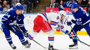 New York Rangers' Barclay Goodrow (21) tries to steal the puck from Toronto Maple Leafs' Matthew Knies (23) as Auston Matthews (34) looks for a pass during second period NHL hockey action. (Frank Gunn/THE CANADIAN PRESS)