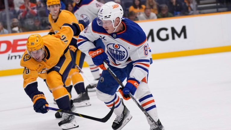 Edmonton Oilers left wing Drake Caggiula (8) skates the puck past Nashville Predators defenseman Brady Skjei (76) during the third period of an NHL hockey game Thursday, Oct. 31, 2024, in Nashville, Tenn. (George Walker IV/AP)