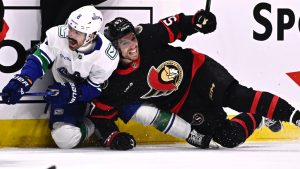 Vancouver Canucks right wing Conor Garland (8) shouts as he clashes along the boards with Ottawa Senators left wing David Perron (57) during second period NHL hockey action in Ottawa, on Saturday, Nov. 23, 2024. (Justin Tang/CP)