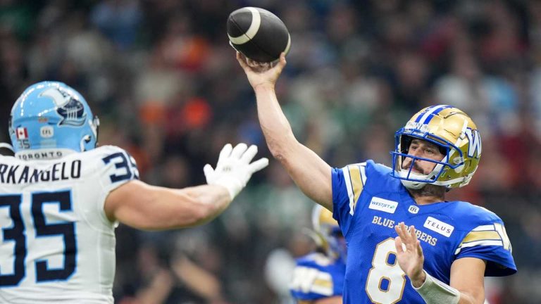 Winnipeg Blue Bombers quarterback Zach Collaros attempts a pass over Toronto Argonauts' Isaac Darkangelo during first half CFL football action at the 111th Grey Cup in Vancouver, B.C. (Frank Gunn/CP)