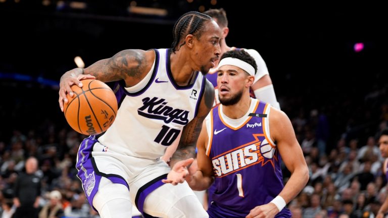 Sacramento Kings forward DeMar DeRozan (10) dribbles past Phoenix Suns guard Devin Booker (1) during the first half of an NBA basketball game, Sunday, Nov. 10, 2024, in Phoenix. (Samantha Chow/AP)