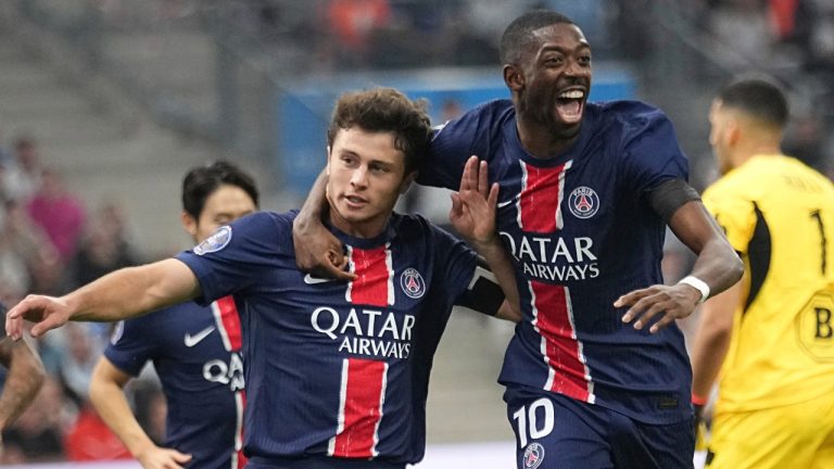 PSG's Joao Neves, left, celebrates with PSG's Ousmane Dembele after scoreing his side opening goal during the League One soccer match between Marseille and Paris Saint-Germain, Sunday, Oct. 27, 2024 at the Velodrome stadium in Marseille, southern France. (Laurent Cipriani/AP)