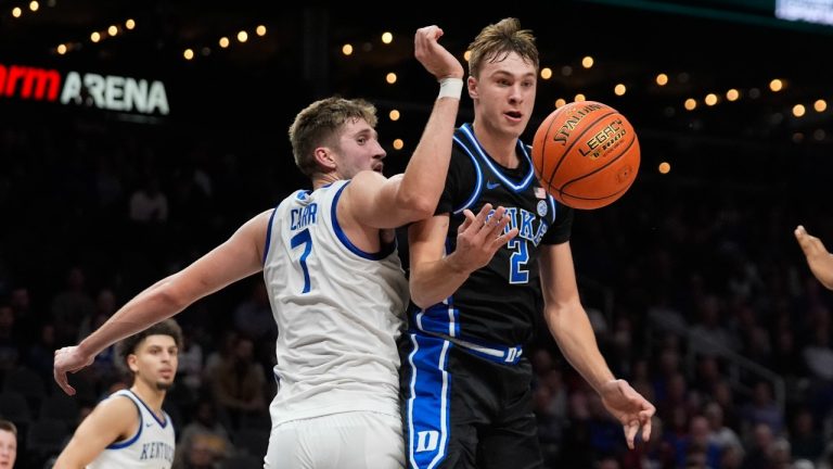 Duke guard Cooper Flagg (2) passes as Kentucky forward Andrew Carr (7) defends during the second half of an NCAA college basketball game, Tuesday, Nov. 12, 2024, in Atlanta. (John Bazemore/AP Photo)