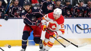 Columbus Blue Jackets forward Kirill Marchenko, left, and Calgary Flames forward Yegor Sharangovich chase the puck during the first period of an NHL hockey game in Columbus, Ohio, Friday, Nov. 29, 2024. (Paul Vernon/AP)