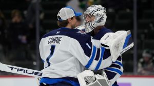 Winnipeg Jets goaltenders Connor Hellebuyck, right, and Eric Comrie (1) hug after their win over the Minnesota Wild in an NHL hockey game, Monday, Nov. 25, 2024, in St. Paul, Minn. (Abbie Parr/AP Photo)