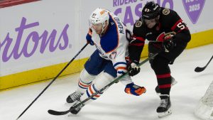 Edmonton Oilers centre Connor McDavid (97) fights off Ottawa Senators left wing David Perron (57) as he skates behind the net with the puck during third period NHL action in Ottawa, Tuesday, Nov. 19, 2024. The Oilers defeated the Senators 5-2. (Adrian Wyld/CP)