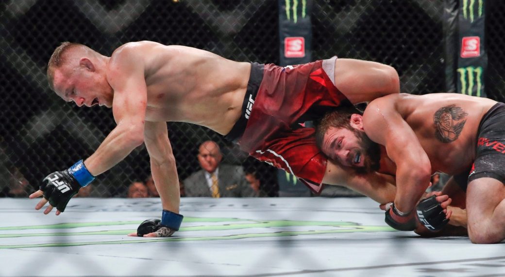 Petr-Yan,-left,-tries-to-get-away-from-the-grasp-of-Jimmie-Rivera-during-their-bantamweight-mixed-martial-arts-bout-at-UFC-238