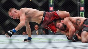 Petr Yan, left, tries to get away from the grasp of Jimmie Rivera during their bantamweight mixed martial arts bout at UFC 238. (Kamil Krzaczynski/AP)