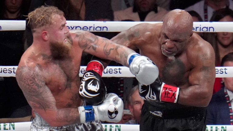 Jake Paul, left, fights Mike Tyson during their heavyweight boxing match, Friday, Nov. 15, 2024, in Arlington, Texas. (Julio Cortez/AP)