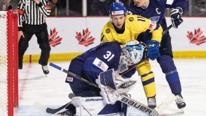 Finland goaltender Jani Lampinen smothers the puck as Sweden's Fabian Wagner looks for a rebound and Finland's Oliver Kapanen defends during third period IIHF World Junior Hockey Championship quarter-final hockey action in Moncton, N.B., on Monday, January 2, 2023. (Ron Ward/CP)