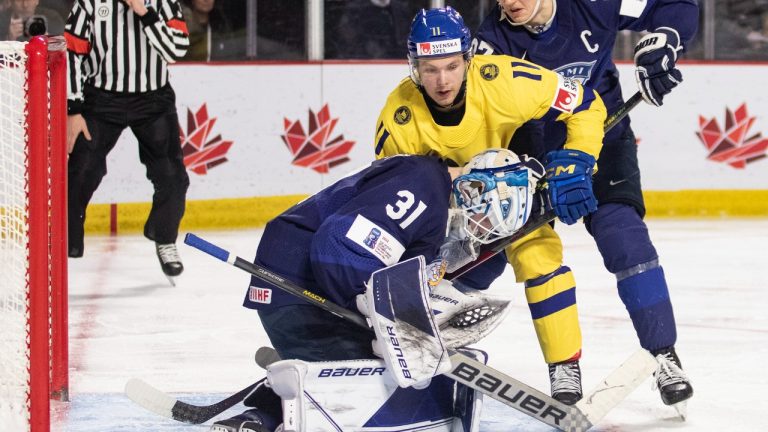 Finland goaltender Jani Lampinen smothers the puck as Sweden's Fabian Wagner looks for a rebound and Finland's Oliver Kapanen defends during third period IIHF World Junior Hockey Championship quarter-final hockey action in Moncton, N.B., on Monday, January 2, 2023. (Ron Ward/CP)