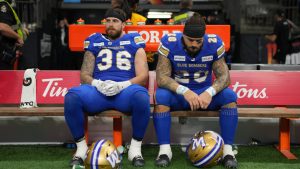 Winnipeg Blue Bombers' Bailey Feltmate (36) and teammate Brady Oliveira (20) sit on the bench after losing the 111th Grey Cup to the Toronto Argonauts, in Vancouver, B.C., Sunday, Nov. 17, 2024. (Ethan Cairns/CP)