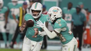 Miami Dolphins quarterback Tua Tagovailoa (1) pitches the football to Miami Dolphins running back De'Von Achane (28) during the second half of an NFL football game against the San Francisco 49ers, Sunday, Dec. 22, 2024, in Miami Gardens, Fla. (Lynne Sladky/AP)