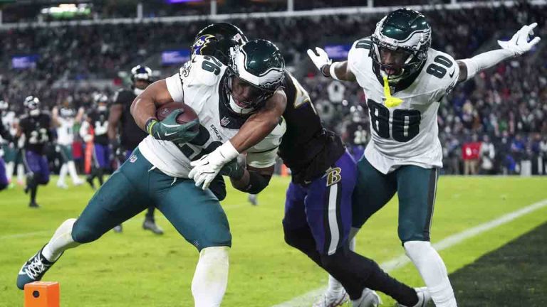 Philadelphia Eagles running back Saquon Barkley, left, is hit by Baltimore Ravens cornerback Marlon Humphrey, center, as Eagles wide receiver Parris Campbell (80) looks on during a touchdown run by Barkley in the second half of an NFL football game, Sunday, Dec. 1, 2024, in Baltimore. (Stephanie Scarbrough/AP)