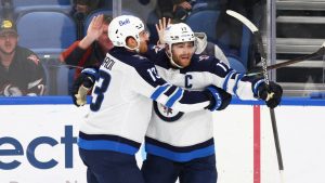 Winnipeg Jets center Adam Lowry (17) celebrates his game winning goal with forward Gabriel Vilardi (13) following the overtime period of an NHL hockey game against the Buffalo Sabres Thursday, Dec. 5, 2024, in Buffalo, N.Y. (Jeffrey T. Barnes/AP)