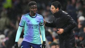 Arsenal's manager Mikel Arteta, right, talks to Arsenal's Bukayo Saka during the English Premier League soccer match between Fulham and Arsenal, at the Craven Cottage Stadium in London, Sunday, Dec. 8, 2024. (AP Photo/Dave Shopland)