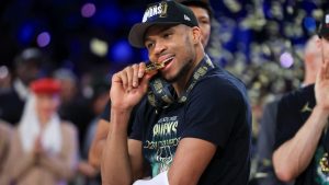 Milwaukee Bucks forward Giannis Antetokounmpo (34) bites his NBA Cup medal after his team's victory in the championship game of the NBA Cup basketball tournament against the Oklahoma City Thunder Tuesday, Dec. 17, 2024, in Las Vegas. (AP Photo/Ian Maule)