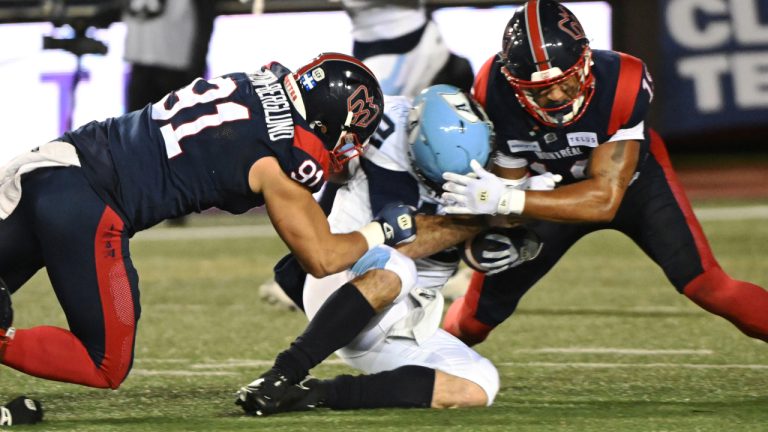 Toronto Argonauts quarterback Chad Kelly (12) is tackled by Montreal Alouettes defensive lineman Isaac Adeyemi-Berglund (91). Saturday, November 9, 2024 in Montreal. THE CANADIAN PRESS/Graham Hughes