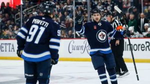 Winnipeg Jets' Neal Pionk (4) and Cole Perfetti (91) celebrate PionkÕs goal against the Minnesota Wild during second period NHL action in Winnipeg on Saturday, December 21, 2024. (John Woods/CP)