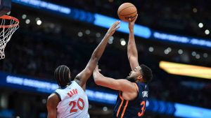 New York Knicks centre Karl-Anthony Towns, right, looks to shoot the ball over Washington Wizards forward Alexandre Sarr (20) during the second half of an NBA basketball game, Monday, Dec. 30, 2024, in Washington. (Terrance Williams/AP)