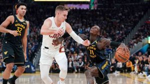 Golden State Warriors guard Dennis Schroder, right, moves the ball while defended by Cleveland Cavaliers guard Sam Merrill (5) during the first half an NBA basketball game Monday, Dec. 30, 2024, in San Francisco. (Kavin Mistry/AP)