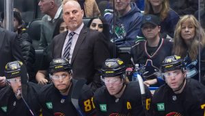 Vancouver Canucks head coach Rick Tocchet stands on the bench behind Pius Suter, from left to right, Dakota Joshua, Brock Boeser and Jake DeBrusk during first period NHL hockey action against the Tampa Bay Lightning, in Vancouver, B.C., Sunday, Dec. 8, 2024. (Darryl Dyck/CP)