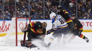 Vancouver Canucks goalie Thatcher Demko (35) stops St. Louis Blues' Dylan Holloway (81) as Vancouver's Noah Juulsen (47) checks him during the second period of an NHL hockey game in Vancouver, on Tuesday, December 10, 2024. (/Darryl Dyck/CP)